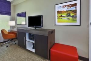 a room with a desk with a television and a chair at Hampton Inn White River Junction in White River Junction