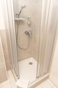 a shower with a glass door in a bathroom at Pension Der kleine Nachbar in Gotha