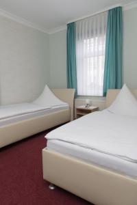 a bedroom with two beds and a window at Pension Der kleine Nachbar in Gotha