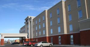 een groot gebouw met auto's ervoor geparkeerd bij Hampton Inn by Hilton Fort Saskatchewan in Fort Saskatchewan