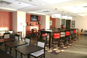 a dining room with tables and chairs in a restaurant at Hampton Inn by Hilton Fort Saskatchewan in Fort Saskatchewan