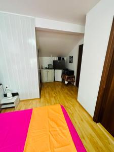 an empty living room with an orange and pink blanket at Apartament Roxi Costinesti in Costinesti