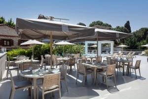 a restaurant with tables and chairs and an umbrella at DoubleTree by Hilton Kusadasi in Kuşadası