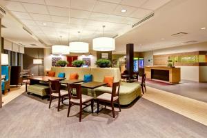 vestíbulo con sofá, mesa y sillas en Home2 Suites by Hilton West Edmonton, en Edmonton