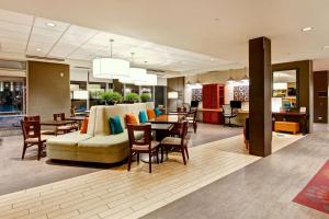 a hotel lobby with a couch and tables and chairs at Home2 Suites by Hilton West Edmonton in Edmonton