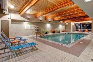 a pool with two lounge chairs and a swimming pool at Home2 Suites by Hilton West Edmonton in Edmonton