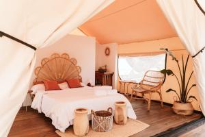 Un dormitorio con una cama grande y una silla. en Dreamsea Mediterranean Camp, en Benitachell