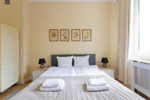 1 dormitorio con 1 cama con 2 toallas en Golden Apartments Warsaw- 3 Separate Rooms Sleep 7 - Best Location&Nowy Świat, en Varsovia