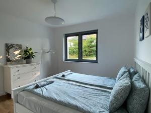 1 dormitorio con cama y ventana en Dom na Wiklinowej en Dobrzewino