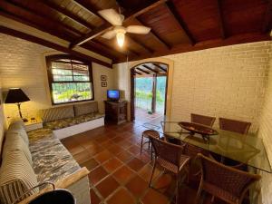 uma sala de estar com uma ventoinha de tecto e uma mesa e cadeiras em Villa do Aconchego em Ubatuba