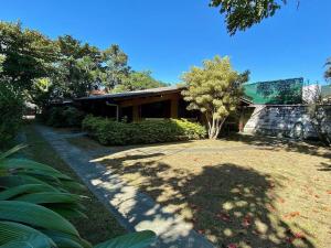 uma casa com um grande quintal com um edifício em Villa do Aconchego em Ubatuba