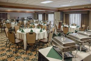 ein Bankettraum mit Tischen und Stühlen und ein Zimmer mit Tischen und einem Stuhl in der Unterkunft Hampton Inn & Suites Youngstown-Canfield in Canfield