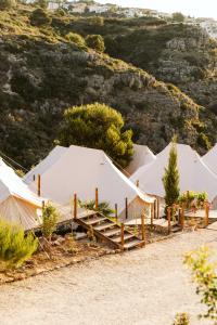 una fila de tiendas blancas delante de una colina en Dreamsea Mediterranean Camp, en Benitachell