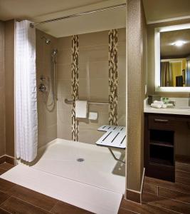 a bathroom with a tub and a shower with a sink at Homewood Suites by Hilton Hamilton in Hamilton