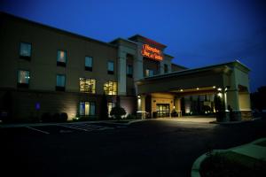 a hotel building with a neon sign on it at Hampton Inn & Suites Sharon in West Middlesex