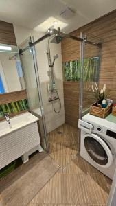 a bathroom with a shower and a washing machine at Smokini Beach Apartment in Sozopol