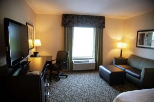 a hotel room with a couch and a television at Hampton Inn & Suites Sharon in West Middlesex