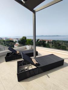 d'un balcon avec deux chaises et une vue sur l'océan. dans l'établissement Seaside residence - Sunset Appartement, à Kožino