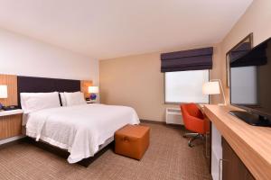 a hotel room with a bed and a flat screen tv at Hampton Inn York in York
