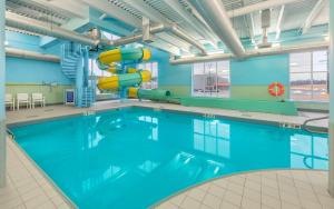 a swimming pool with a slide in a building at Hampton Inn Sydney in Sydney