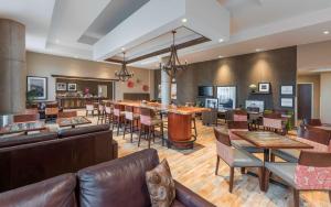 a lobby with a bar and tables and chairs at Hampton Inn Sydney in Sydney