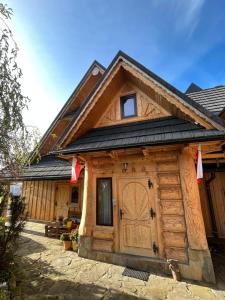 Cabaña de madera con una gran puerta de madera en Pokoje Goscinne u Naglaka Willa Zab en Ząb