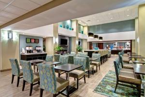 a restaurant with tables and chairs and a bar at Hampton Inn Sudbury, Ontario in Sudbury