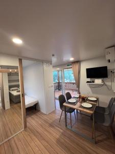 ein Wohnzimmer mit einem Tisch, Stühlen und einem TV in der Unterkunft Mobile House F&L in Biograd na Moru