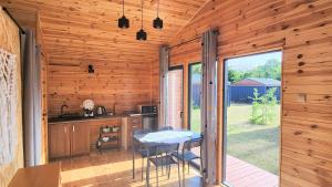a kitchen with a table and chairs in a cabin at Reset Camp domki wakacyjne in Siecie