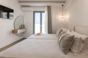 a white bedroom with a large bed and a mirror at Aeron Villas and Suites Naxos in Agia Anna Naxos +43 photos