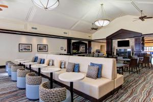 Homewood Suites by Hilton Toronto-Mississauga في ميسيساوغا: غرفة انتظار مع أريكة بيضاء وطاولات
