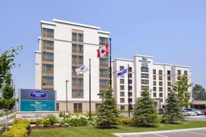 un hôtel avec des drapeaux devant un bâtiment dans l'établissement Homewood Suites by Hilton Toronto Airport Corporate Centre, à Toronto