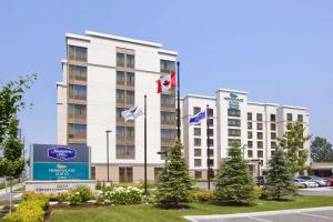 a hotel with flags in front of a building at Homewood Suites by Hilton Toronto Airport Corporate Centre in Toronto