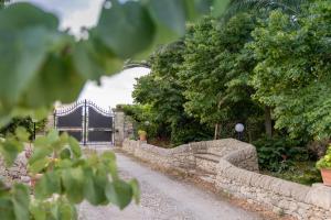 a stone fence and a gate with a bridge at Casale Della Contea in Modica