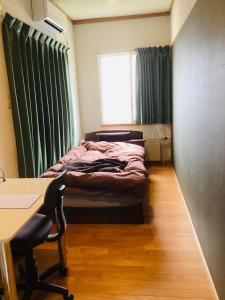 a bedroom with a bed and a desk and a window at Kamome Building 3F - Vacation STAY 50177v in Otaru