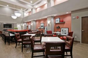 a restaurant with tables and chairs and a bar at Hampton Inn & Suites by Hilton Toronto Markham in Markham
