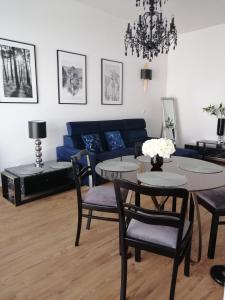 Apartament Lipska في زاموسك: غرفة معيشة مع أريكة زرقاء وطاولة وكراسي