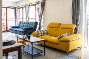 sala de estar con sofá amarillo y mesa en Center PENTHOUSE apartment - HUGE TERRACE and FREE PARKING - Tram/Metro - AC, en Budapest