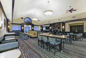 a hotel lobby with tables and chairs and a bar at Homewood Suites by Hilton Cambridge-Waterloo, Ontario in Cambridge