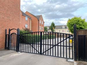 a black metal gate in front of a brick building at Sweet home 2 Double bedrooms apartment free parking Summertown, Oxford in Oxford