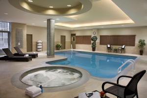 een groot zwembad met een hot tub in een hotelkamer bij Homewood Suites by Hilton Toronto Vaughan in Vaughan