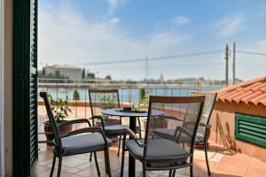 a patio with four chairs and a table on a balcony at Villa Hresc M in Zadar