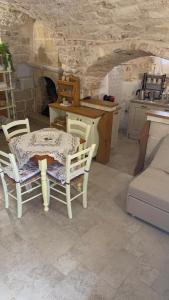 een keuken met een tafel en stoelen en een bank bij Casa vacanza Appia Antica in Carovigno +3 foto's