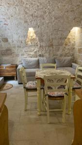 un tavolo e sedie in una stanza con divano di Casa vacanza Appia Antica a Carovigno