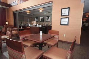 a restaurant with wooden tables and chairs and a bar at Hampton Inn & Suites Vineland in Vineland