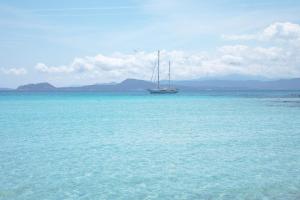 una barca a vela seduta in mezzo all'oceano di Hotel Castello a Golfo Aranci