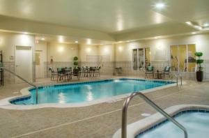 a pool in a hotel with tables and chairs at Hilton Garden Inn Ames in Ames