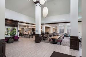 a lobby with tables and chairs and a restaurant at Hilton Garden Inn Ames in Ames