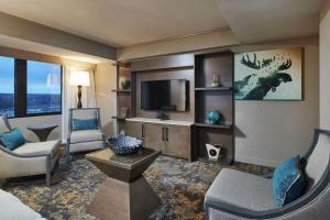 a living room with a couch and a tv at Hilton Anchorage in Anchorage
