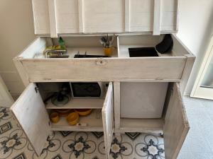 um armário de madeira com um lavatório num quarto em Favolosa stanza gialla con terrazzino vista mare Mottino23 em Lerici